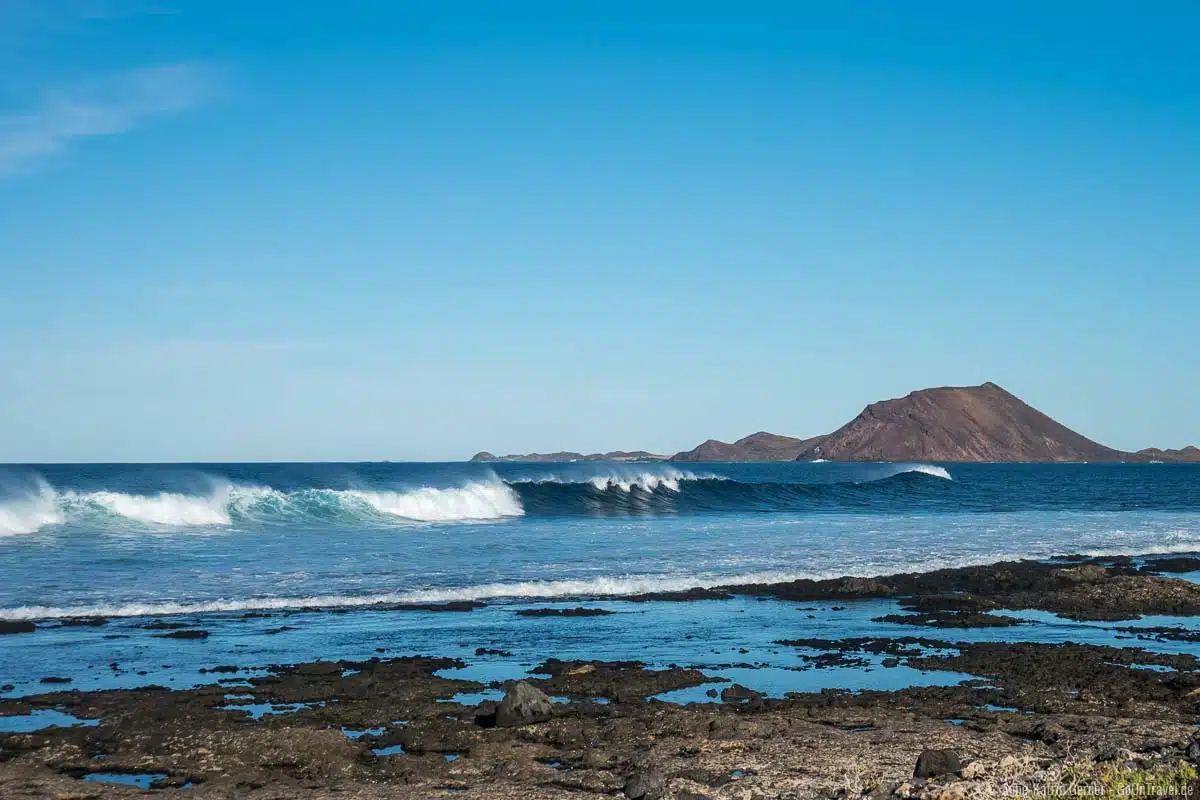 Lavaküste und Traumwellen mit Blick auf die Insel Lobos und das ganz in Hafennähe. Lavaküste und Traumwellen mit Blick auf die Insel Lobos und das ganz in Hafennähe.