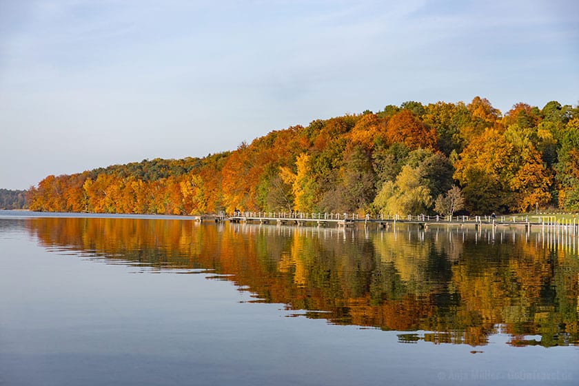 Bunter Herbstwald spiegelt sich im Wasser