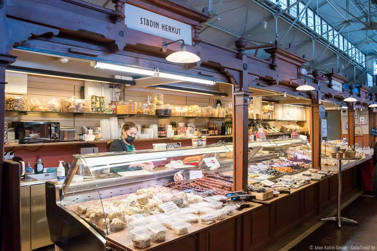 An den Ständen in der historischen Markthalle gibt es viele lokale Gerichte und Produkte An den Ständen in der historischen Markthalle gibt es viele lokale Gerichte und Produkte