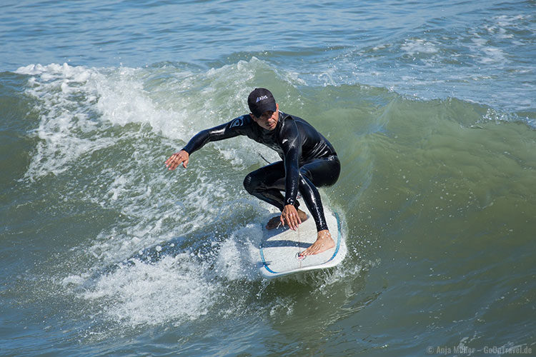 Ein Surfer beim Wellenreiten am Cocoa Beach Pier
